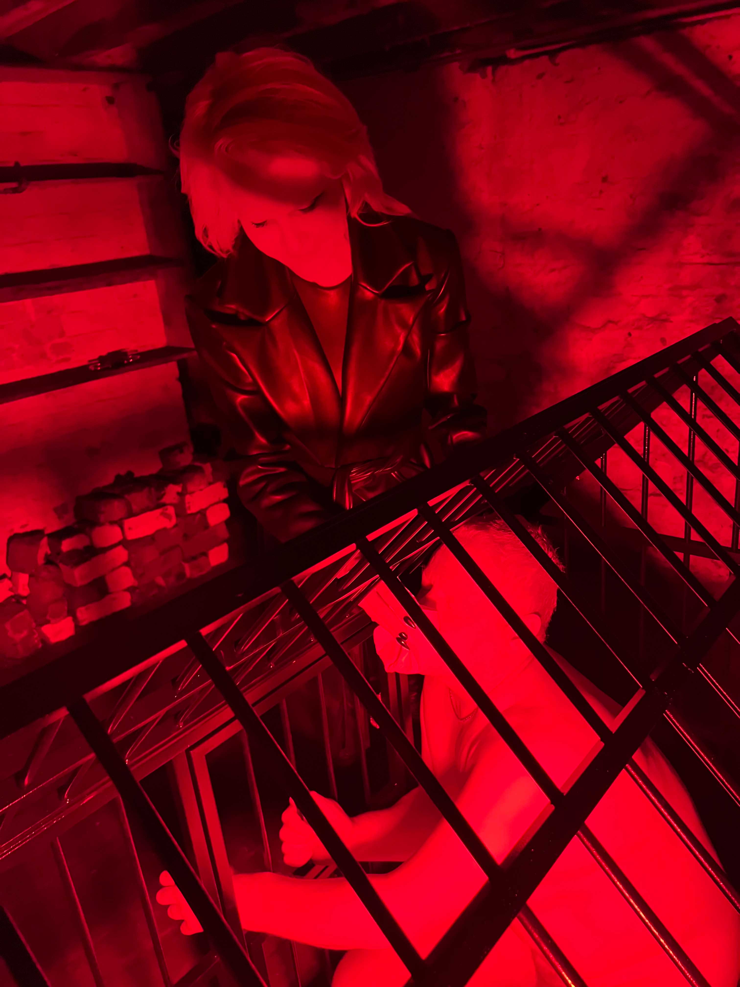 Red-lit cage scene from a previous consensual roleplay experience