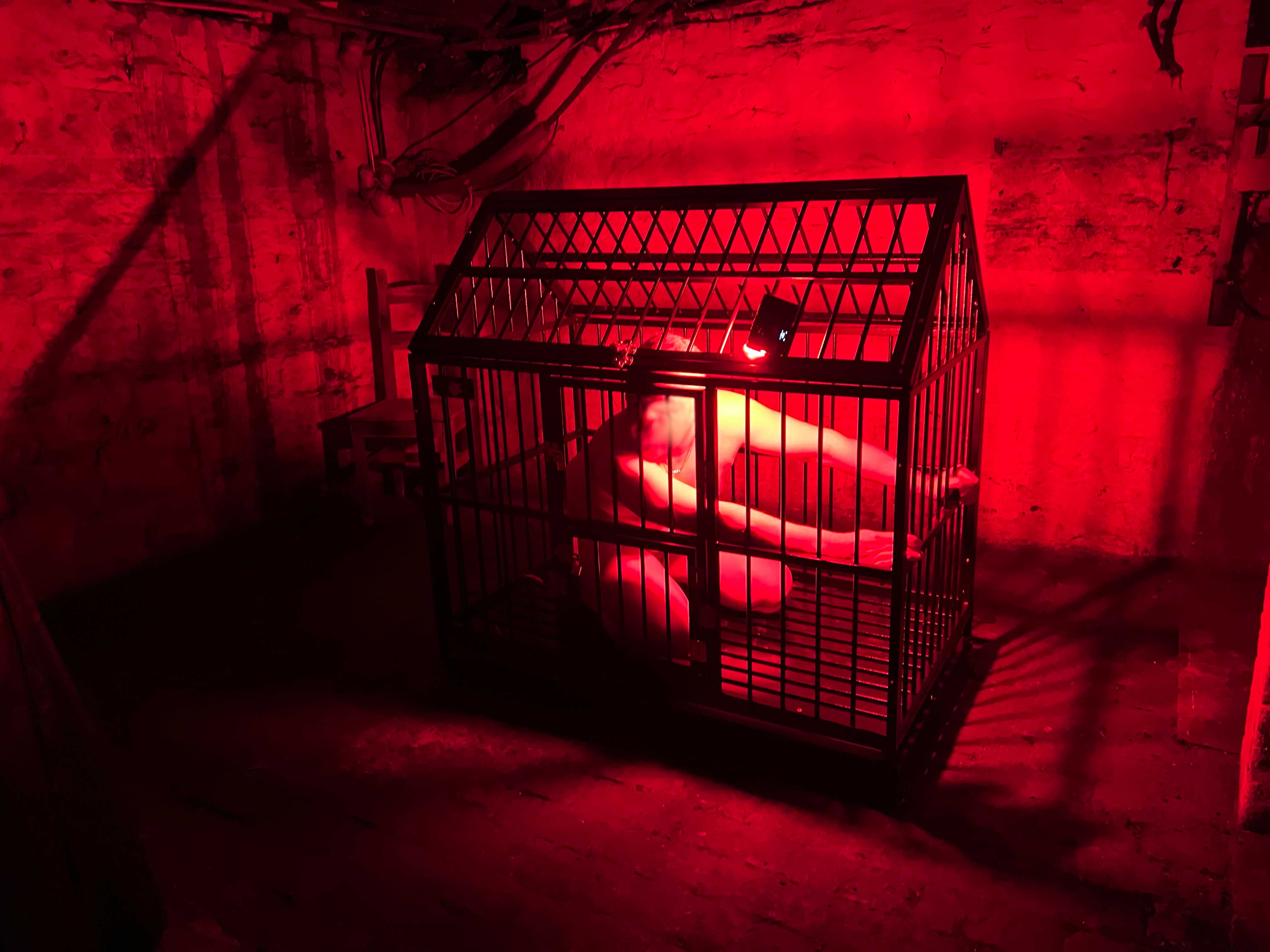 Red-lit cage scene from a previous consensual roleplay experience